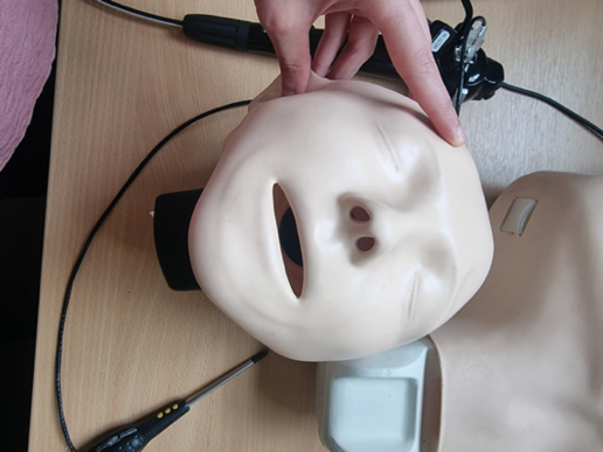 A basic resuscitation training manikin is used. The silicone/rubber skin is removed.